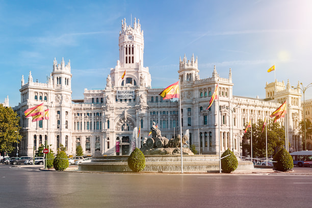 plaza de cibeles madrid avec ciel bleu et drapeau espagnol